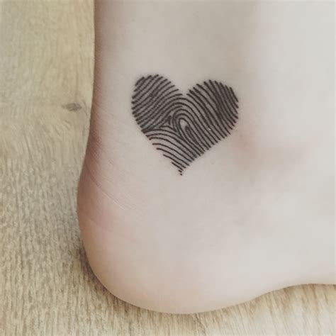 This is a popular choice among couples, serving as a beautiful testament to their bond. . Fingerprint heart tattoo couple